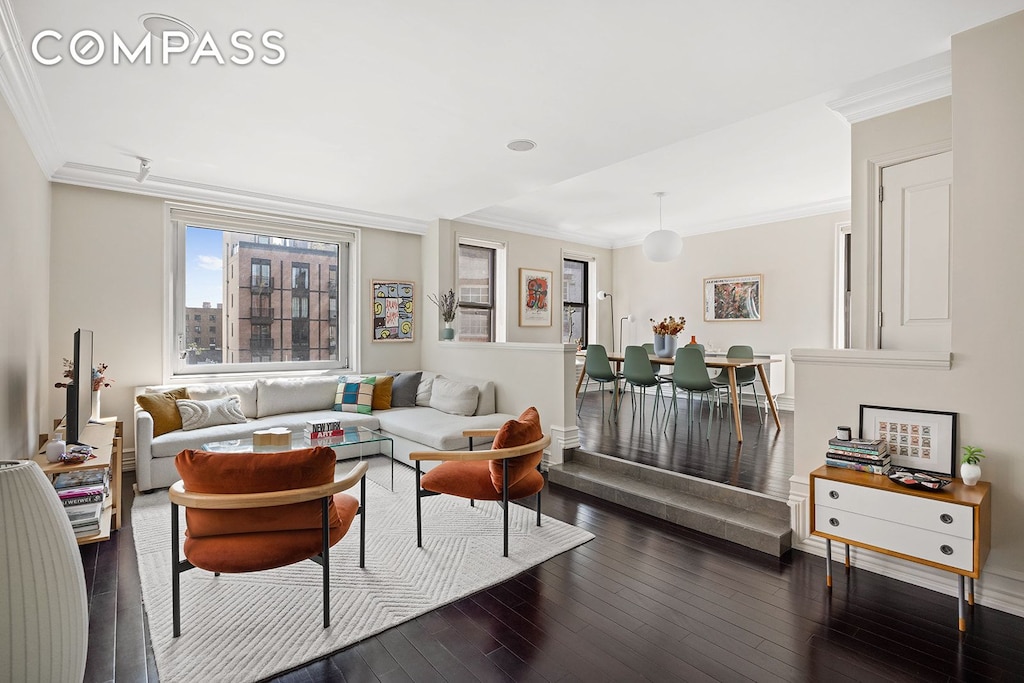 living area featuring dark wood-style flooring and ornamental molding