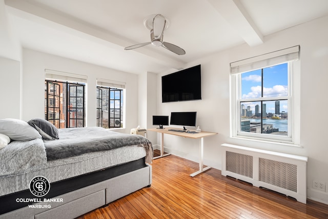 25 Tudor City Pl Unit 301, New York City, NY 10017 - bedroom featuring radiator, baseboards, wood-type flooring, and beam ceiling
