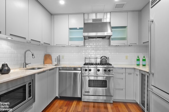 50 W 15th St Unit C1, New York City, NY 10011 - kitchen featuring premium appliances, under cabinet range hood, wine cooler, backsplash, and white cabinetry