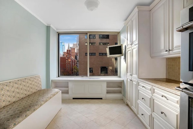bathroom with backsplash, tile patterned flooring, and crown molding