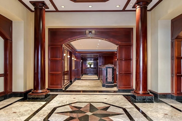 hall with inlaid floor details, decorative columns, crown molding, baseboards, and recessed lighting
