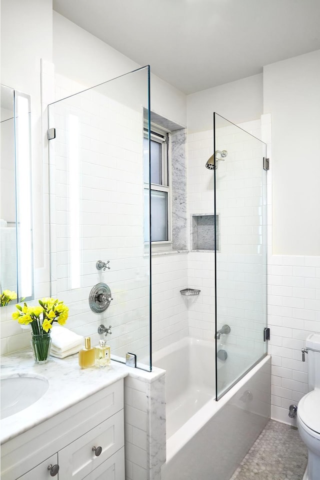 541 E 72nd St Unit 2/3, New York City, NY 10021 - bathroom with tile walls, vanity, combined bath / shower with glass door, and toilet