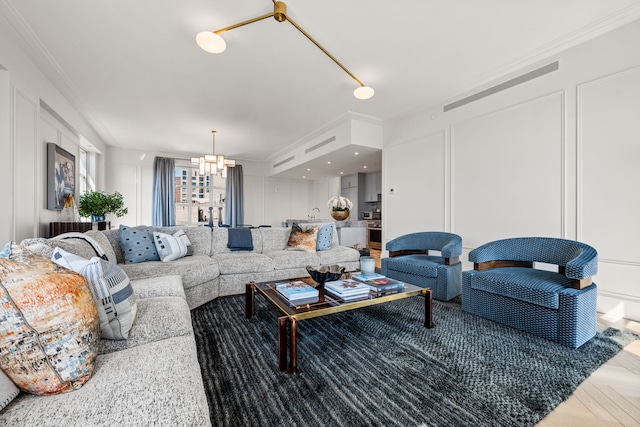 living area featuring a chandelier, a decorative wall, and ornamental molding