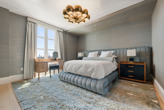bedroom featuring baseboards, a chandelier, wood finished floors, and wallpapered walls