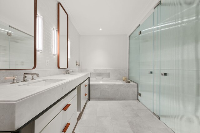 bathroom featuring a shower stall, a garden tub, double vanity, and crown molding