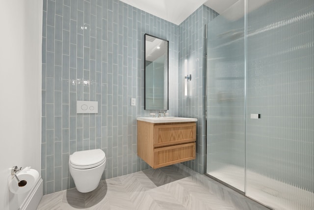full bath featuring tile walls, a shower with door, vanity, and toilet
