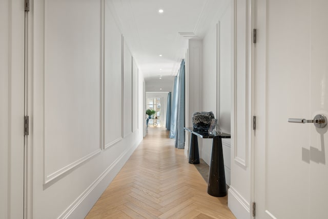 hallway with recessed lighting, a decorative wall, and crown molding