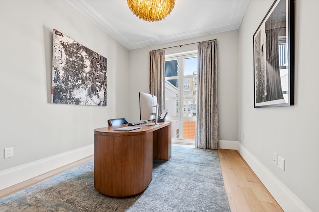 office space with light wood-type flooring, crown molding, a chandelier, and baseboards