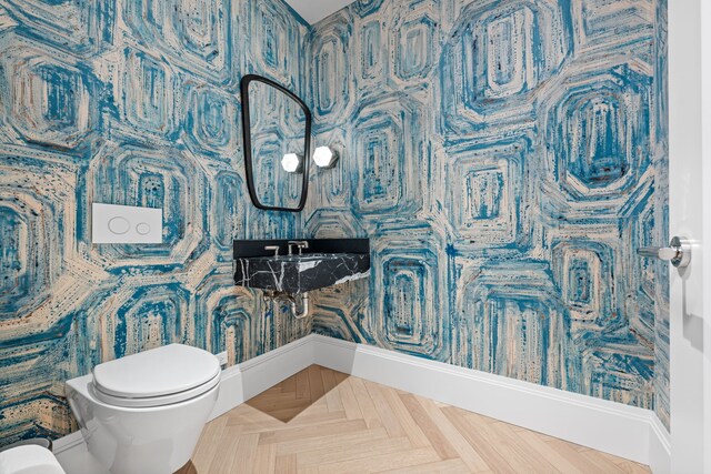 bathroom featuring toilet and baseboards
