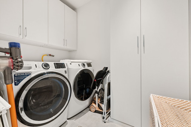 laundry area with washer and clothes dryer, cabinet space, and light tile patterned flooring