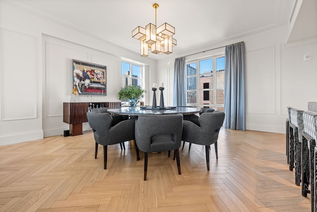 dining area with a chandelier, a decorative wall, and baseboards