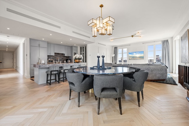 dining space featuring a chandelier, ornamental molding, and recessed lighting