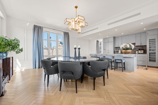 dining area featuring a decorative wall, recessed lighting, a chandelier, and ornamental molding