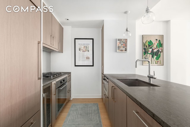 160 E 22nd St Unit 3A, New York City, NY 10010 - kitchen with a sink, stainless steel appliances, light wood-style flooring, beverage cooler, and pendant lighting