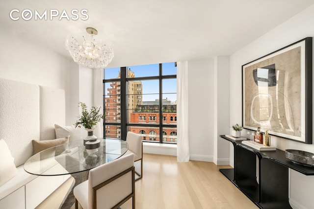 150 Charles St Unit 14B, New York City, NY 10014 - dining space featuring light wood-type flooring, baseboards, a chandelier, and floor to ceiling windows