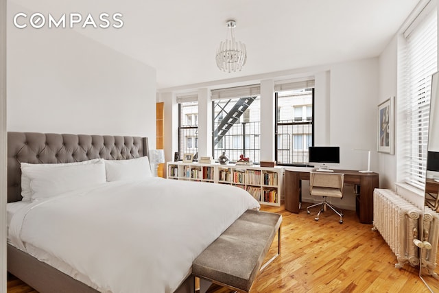 1 Hudson St Unit 9, New York City, NY 10013 - bedroom featuring radiator, light wood-style flooring, an office area, and a chandelier