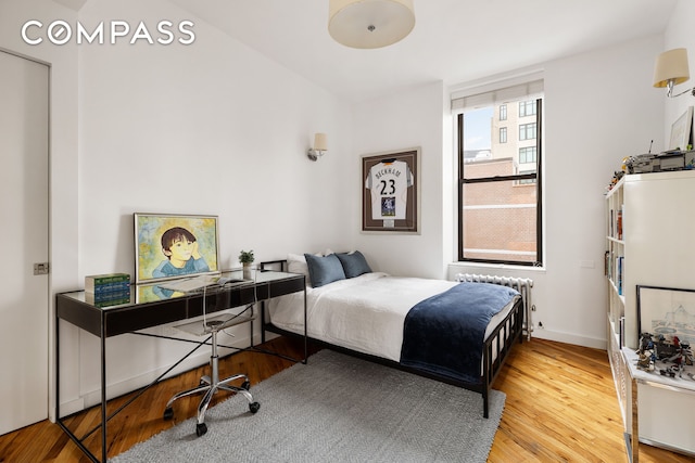 bedroom featuring radiator heating unit and wood finished floors