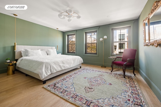 bedroom featuring visible vents, baseboards, and wood finished floors