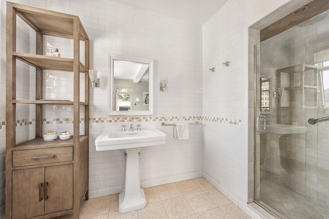 full bath with a sink, tile patterned flooring, tile walls, tasteful backsplash, and a stall shower