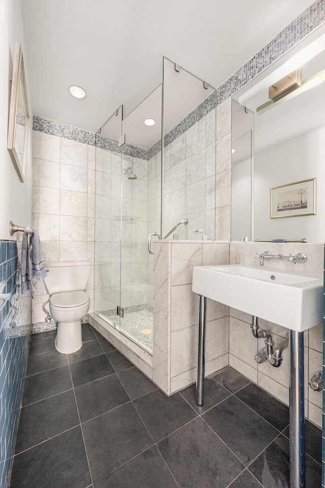 875 5th Ave Unit 12Ef, New York City, NY 10065 - bathroom with tile walls, toilet, a shower stall, tile patterned flooring, and recessed lighting