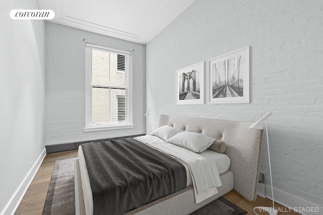 bedroom with baseboards and wood finished floors