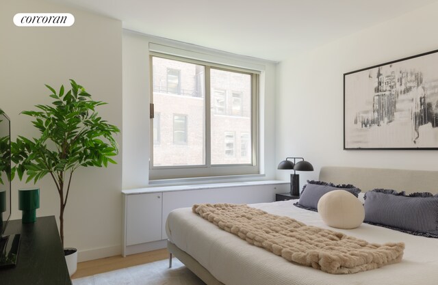 234 E 46th St Unit 605, New York City, NY 10017 - bedroom featuring multiple windows, light wood-style flooring, and baseboards