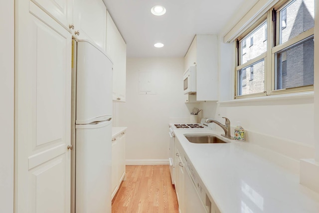434 E 52nd St Unit 6D, New York City, NY 10022 - kitchen featuring a sink, light countertops, white appliances, and light wood-style floors