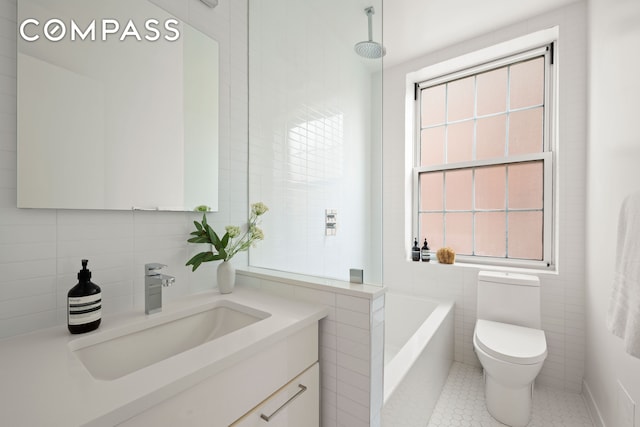 full bathroom featuring toilet, tile walls, and plenty of natural light