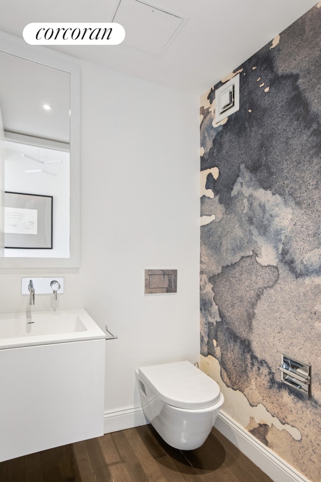 bathroom with wood finished floors, toilet, baseboards, and vanity