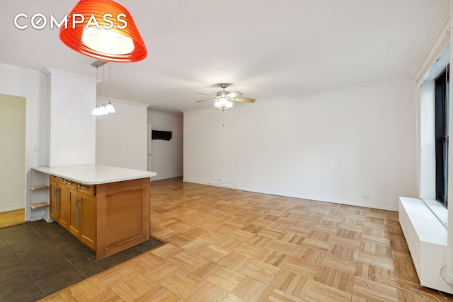 355 Clinton Ave Unit 1F, New York City, NY 11238 - kitchen with a ceiling fan, light countertops, brown cabinetry, crown molding, and pendant lighting