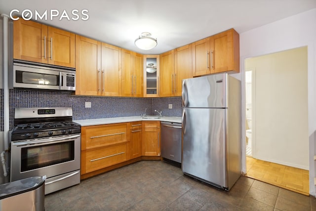 355 Clinton Ave Unit 1F, New York City, NY 11238 - kitchen featuring appliances with stainless steel finishes, light countertops, tasteful backsplash, glass insert cabinets, and dark tile patterned floors