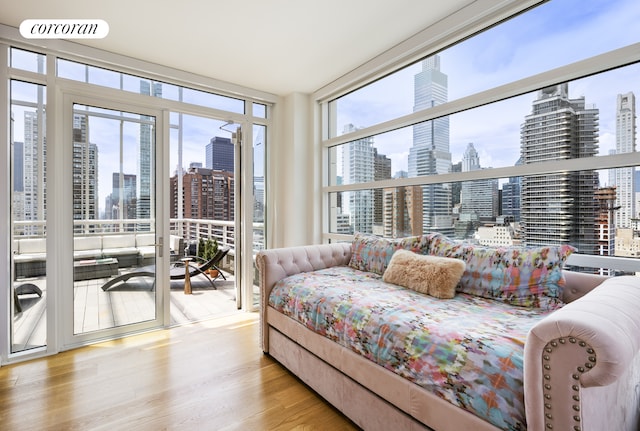 301 E 61st Street Penthouse, New York City, NY 10065 - bedroom featuring a view of skyline, expansive windows, access to outside, multiple windows, and wood finished floors