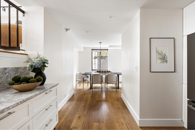 hallway with wood-type flooring and baseboards