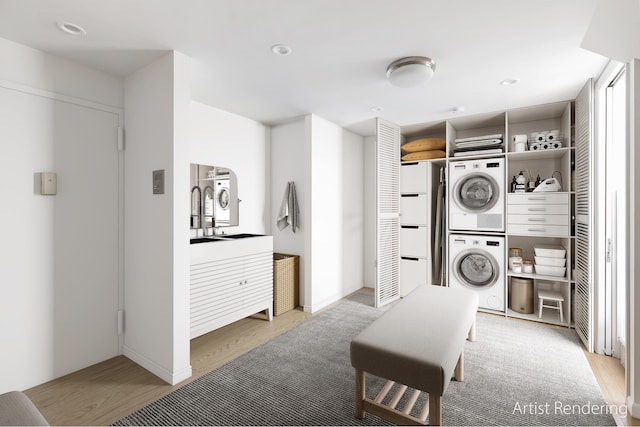 clothes washing area with stacked washer / drying machine, light wood-style flooring, and recessed lighting