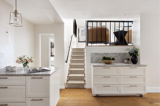staircase featuring wood finished floors and baseboards