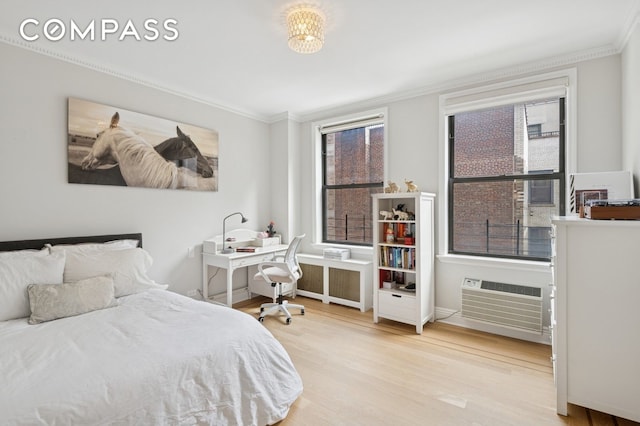 bedroom with radiator, crown molding, a wall unit AC, and wood finished floors