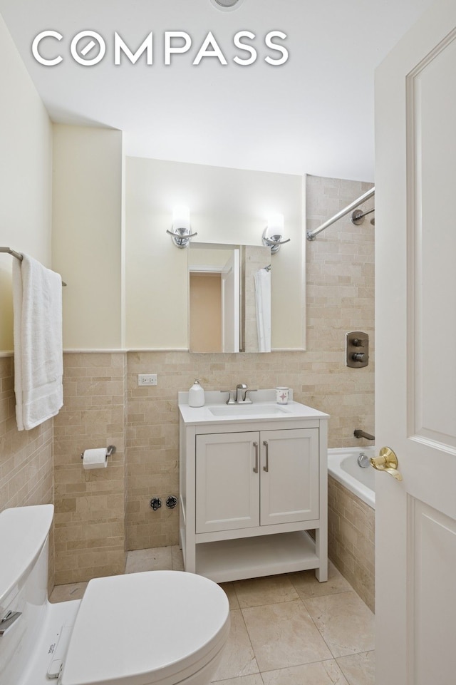bathroom with vanity, toilet, tile patterned flooring, and tile walls