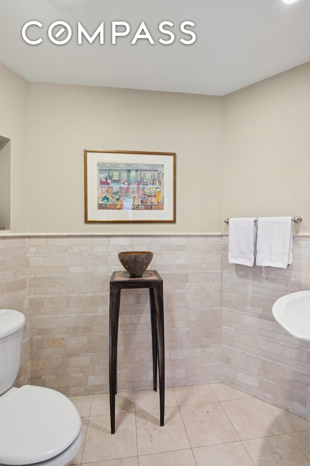 514 W End Ave Unit 8/9A, New York City, NY 10024 - half bath with tile walls, toilet, a wainscoted wall, and tile patterned floors