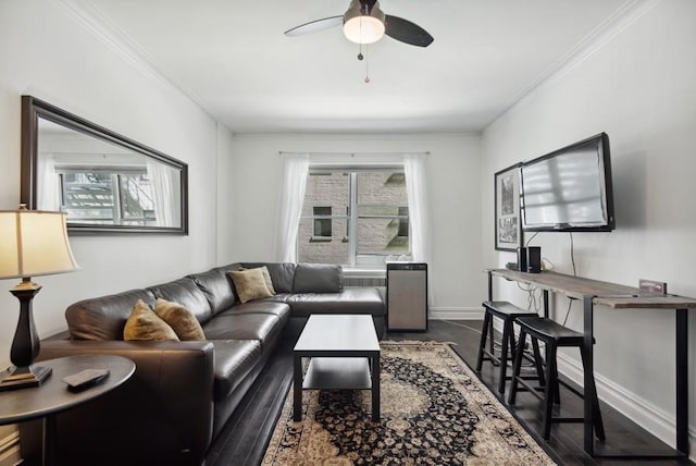 living room featuring ornamental molding, a ceiling fan, dark wood finished floors, and baseboards