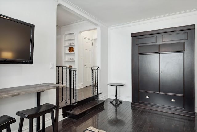 foyer entrance featuring baseboards, dark wood finished floors, and ornamental molding