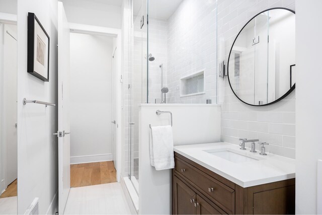 242 Lafayette St Unit 2N, New York City, NY 10012 - full bathroom featuring vanity, a shower stall, backsplash, and wood finished floors