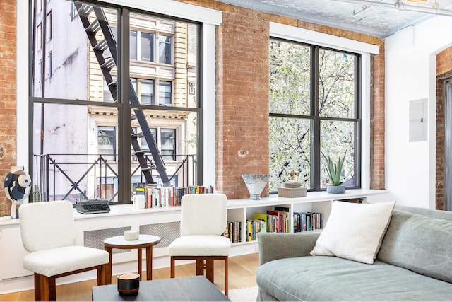242 Lafayette St Unit 2N, New York City, NY 10012 - living area featuring brick wall, wood finished floors, and electric panel
