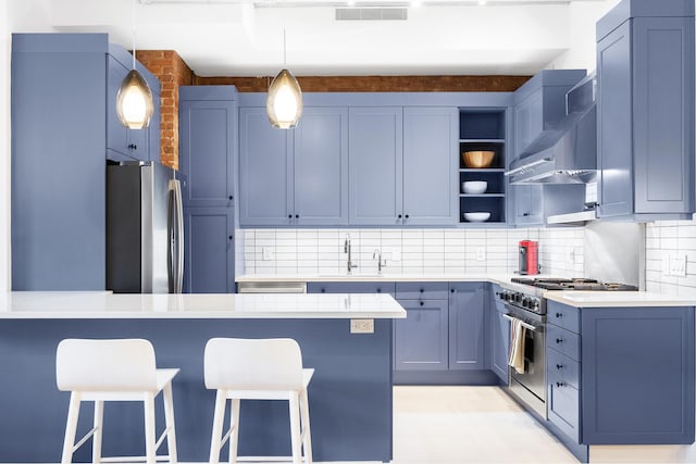 242 Lafayette St Unit 2N, New York City, NY 10012 - kitchen featuring appliances with stainless steel finishes, a sink, a peninsula, a breakfast bar area, and wall chimney exhaust hood