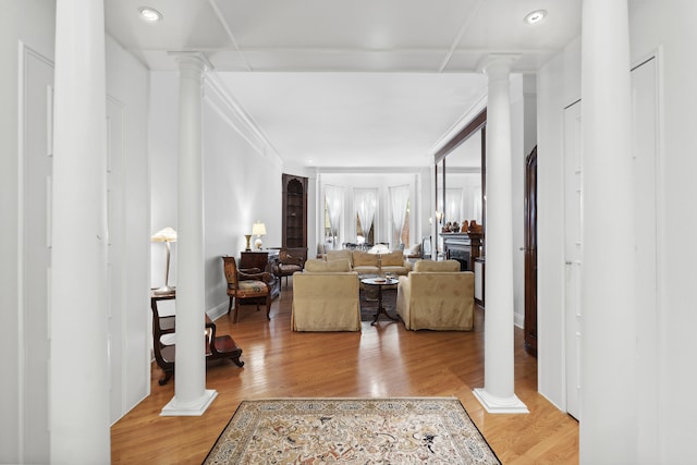 corridor featuring decorative columns, recessed lighting, and light wood-style flooring
