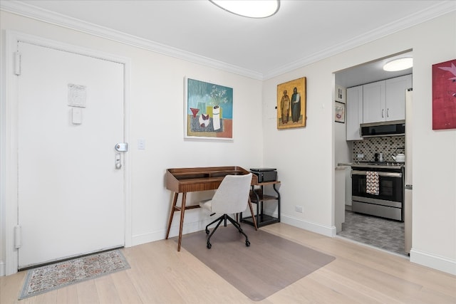 office space with crown molding, baseboards, and light wood-style flooring