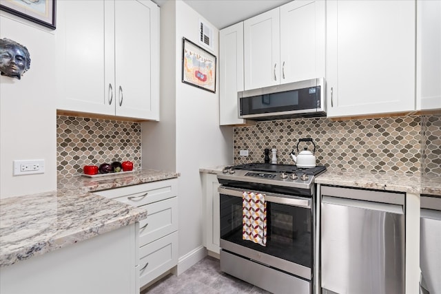 kitchen featuring visible vents, decorative backsplash, white cabinetry, and stainless steel appliances