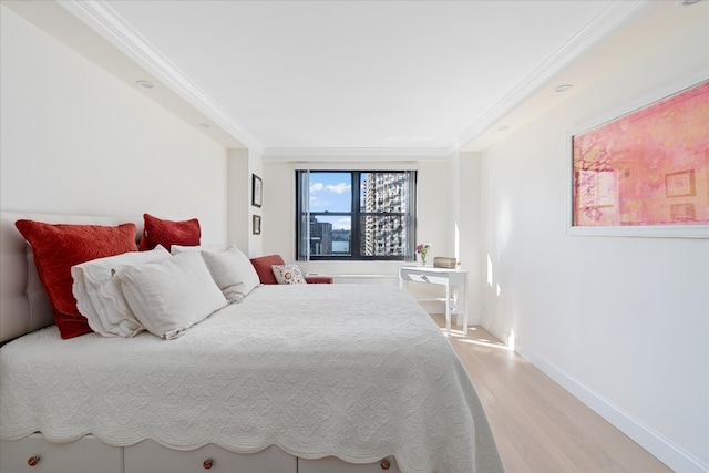 bedroom featuring light wood-type flooring, baseboards, and crown molding