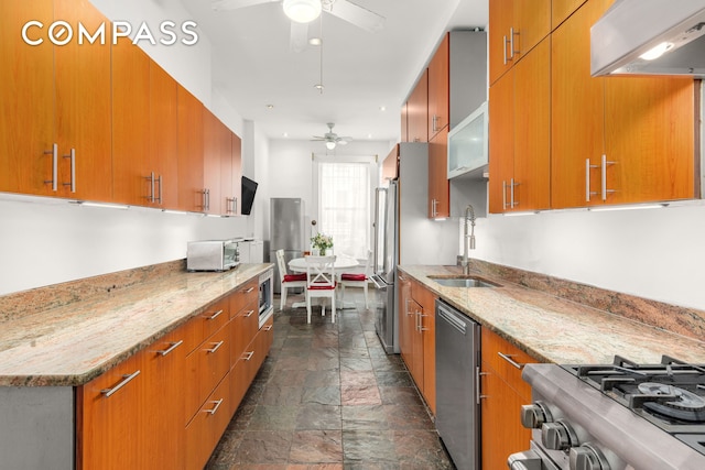 517 E 87th St Unit 1, New York City, NY 10128 - kitchen featuring a ceiling fan, stone tile floors, wall chimney range hood, stainless steel appliances, and a sink