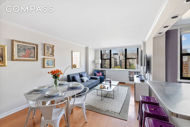 living area featuring crown molding, healthy amount of natural light, and wood finished floors