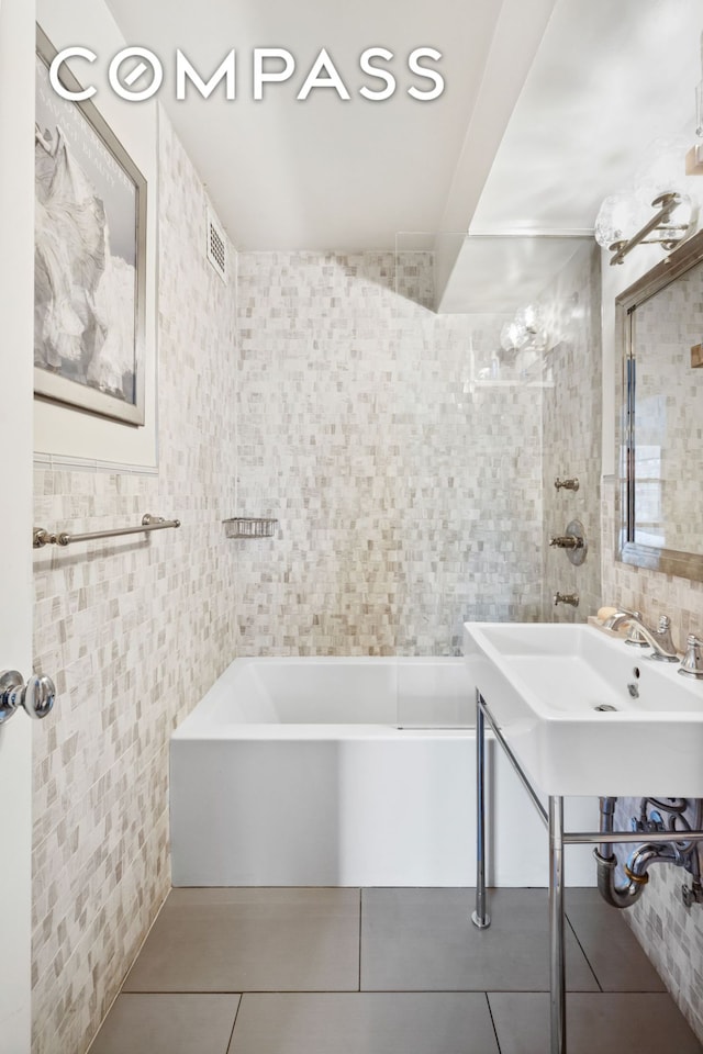 full bathroom with tile walls, tile patterned floors, and washtub / shower combination